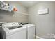 Laundry room featuring a white washer and dryer, with upper shelving for storage at 3020 Fallondale Rd, Waxhaw, NC 28173