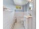 Compact bathroom featuring white tile walls, a vanity sink, toilet, and a window at 330 S Ellis St, Salisbury, NC 28144