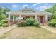 Charming brick home with a covered porch, white pillars, and mature landscaping at 330 S Ellis St, Salisbury, NC 28144