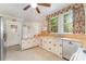 Well-lit kitchen with light cabinets, stainless steel dishwasher, laminate countertops, and floral curtains at 330 S Ellis St, Salisbury, NC 28144