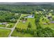 Stunning aerial view of a private estate with a pool, pond, and lush green landscaping surrounded by trees at 3381 Elaine Ave, Lincolnton, NC 28092