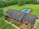Aerial view of a brick home with a fenced pool, landscaped yard, and a charming front porch at 3381 Elaine Ave, Lincolnton, NC 28092