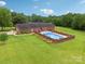 Aerial view of a landscaped backyard featuring a pool, patio, and well-maintained lawn surrounding a brick home at 3381 Elaine Ave, Lincolnton, NC 28092