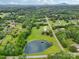 Expansive aerial view features a large pond, with lush green trees, multiple homes and vast landscape at 3381 Elaine Ave, Lincolnton, NC 28092