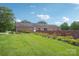 Lush backyard with a brick wall lined with flowers, showcasing the home's exterior and landscaping at 3381 Elaine Ave, Lincolnton, NC 28092