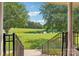Picturesque backyard view from porch stairs, showcasing lush greenery, a serene pond, and a charming gazebo at 3381 Elaine Ave, Lincolnton, NC 28092