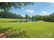 Aerial view of tranquil pond featuring a dock, storage shed and lush green landscaping all around at 3381 Elaine Ave, Lincolnton, NC 28092