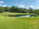 Picturesque pond with a small gazebo and shed, surrounded by lush greenery and a well-maintained lawn at 3381 Elaine Ave, Lincolnton, NC 28092