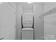Bright laundry area features a stacked washer and dryer, maximizing space and convenience with storage shelving at 514 W 10Th St # 302, Charlotte, NC 28202
