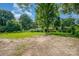 Wide open backyard featuring a blend of grass and ground cover with mature trees throughout at 5323 Snow White Ln, Charlotte, NC 28213