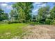 Expansive backyard featuring mature trees and a lush lawn, perfect for outdoor activities at 5323 Snow White Ln, Charlotte, NC 28213