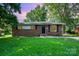 Charming one-story brick home with mature trees and well-maintained front lawn at 5323 Snow White Ln, Charlotte, NC 28213