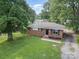 Charming single-story brick home featuring a well-maintained lawn and mature trees at 5323 Snow White Ln, Charlotte, NC 28213