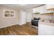 Bright kitchen features white cabinets, a stainless steel range, and laminate flooring at 5323 Snow White Ln, Charlotte, NC 28213