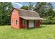 Exterior view of a charming red barn with white trim in a lush, green field at 544 Hicks Creek Rd, Troutman, NC 28166