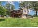 Exterior view of home showing screened porch, deck, stone foundation, and spacious yard with mature trees at 544 Hicks Creek Rd, Troutman, NC 28166