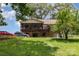 Exterior view of home showing screened porch, deck, stone foundation, and spacious yard with mature trees at 544 Hicks Creek Rd, Troutman, NC 28166