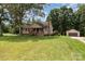 Inviting single-Gathering home with a charming front porch, mature trees, detached garage, and spacious green lawn at 544 Hicks Creek Rd, Troutman, NC 28166