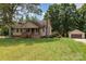 Inviting single-Gathering home with a stone chimney, front porch, mature trees, detached garage, and spacious green lawn at 544 Hicks Creek Rd, Troutman, NC 28166
