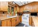 Bright kitchen with wooden cabinets, countertop with sink and a white range at 544 Hicks Creek Rd, Troutman, NC 28166
