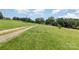 Expansive green lawn with a winding gravel driveway leading to the main house in the background at 544 Hicks Creek Rd, Troutman, NC 28166