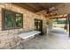 Covered patio with stone accents, ceiling fans, and view of an expansive lawn at 544 Hicks Creek Rd, Troutman, NC 28166
