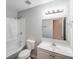 Bright bathroom featuring a tub and shower combination, with a white vanity and a well-lit mirror at 6513 Old Post Rd, Charlotte, NC 28212