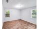 Empty bedroom with hardwood flooring, natural light from two windows, and neutral paint at 6513 Old Post Rd, Charlotte, NC 28212