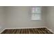 A cozy bedroom with neutral walls, a window with blinds, and wood-look laminate flooring at 6513 Old Post Rd, Charlotte, NC 28212