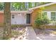 Charming single-story home front entrance featuring a dark front door, sidelight and lush landscaping at 6513 Old Post Rd, Charlotte, NC 28212