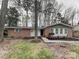 Charming single-story brick home with a well-manicured lawn and mature trees, offering great curb appeal at 6513 Old Post Rd, Charlotte, NC 28212