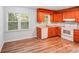 Kitchen view with wood cabinets, laminate countertops, white appliances, and wood-look floors at 6513 Old Post Rd, Charlotte, NC 28212