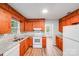 Kitchen with wood cabinets, stone countertops, and white appliances at 6513 Old Post Rd, Charlotte, NC 28212