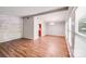 Open-concept living room with wood floors, brick accent wall, and lots of natural light at 6513 Old Post Rd, Charlotte, NC 28212