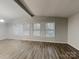Inviting living room with a vaulted ceiling, sleek flooring, and three large windows bringing in plenty of natural light at 6513 Old Post Rd, Charlotte, NC 28212