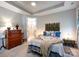 Calm bedroom with tray ceiling, vintage furniture, and a cozy bed with quilts and decorative pillows at 7337 Overjoyed Xing, Charlotte, NC 28215