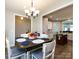 Open-concept dining area flowing into a modern kitchen with an island and white cabinets at 7337 Overjoyed Xing, Charlotte, NC 28215