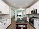 Well-lit kitchen with white cabinets, stainless steel appliances, a kitchen island, and hardwood floors at 7337 Overjoyed Xing, Charlotte, NC 28215