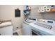Bright laundry room with modern washer and dryer, granite countertop and overhead shelving at 7337 Overjoyed Xing, Charlotte, NC 28215
