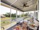 Screened-in porch featuring a seating area, ceiling fan, and views of a lush backyard and pond at 7337 Overjoyed Xing, Charlotte, NC 28215