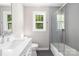 Modern bathroom with gray subway tile shower, quartz vanity, and large window at 7407 Limerick Dr, Charlotte, NC 28270
