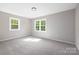 Bright bedroom featuring two windows, neutral paint, and plush carpet flooring at 7407 Limerick Dr, Charlotte, NC 28270