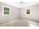 Well-lit bedroom with carpet flooring and two windows providing natural light at 7407 Limerick Dr, Charlotte, NC 28270
