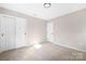 Cozy bedroom includes a closet, neutral paint, carpeted floors, and modern lighting at 7407 Limerick Dr, Charlotte, NC 28270