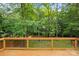 Wooden deck featuring black metal railings overlooking green grass and trees at 7407 Limerick Dr, Charlotte, NC 28270