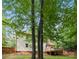 Back of house featuring a wooden deck, mature trees, and a fenced yard at 7407 Limerick Dr, Charlotte, NC 28270