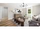 Bright living room featuring modern decor, wood floors, large windows, and a stylish chandelier at 7407 Limerick Dr, Charlotte, NC 28270