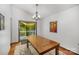 Cozy dining area with wood table, chandelier, and sliding glass door to outdoor space with hardwood floors at 7434 Lawyers Station Dr, Mint Hill, NC 28227