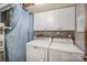 Bright laundry room with white cabinets, modern appliances, and tiled backsplash at 7434 Lawyers Station Dr, Mint Hill, NC 28227