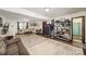 Open living room featuring a sectional sofa, sliding door to deck, and shelving at 7434 Lawyers Station Dr, Mint Hill, NC 28227